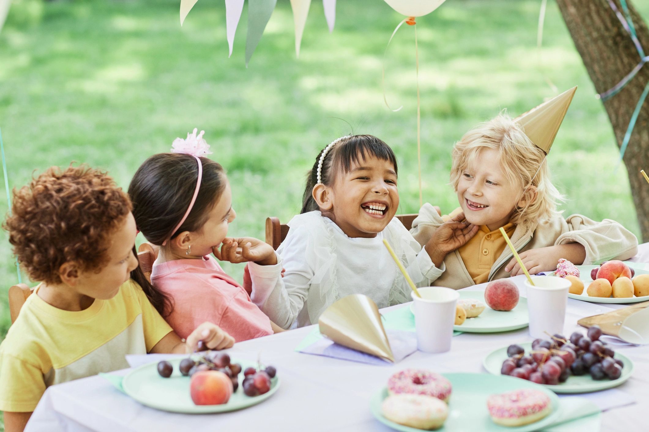 Kids birthday party at an outdoor picnic table