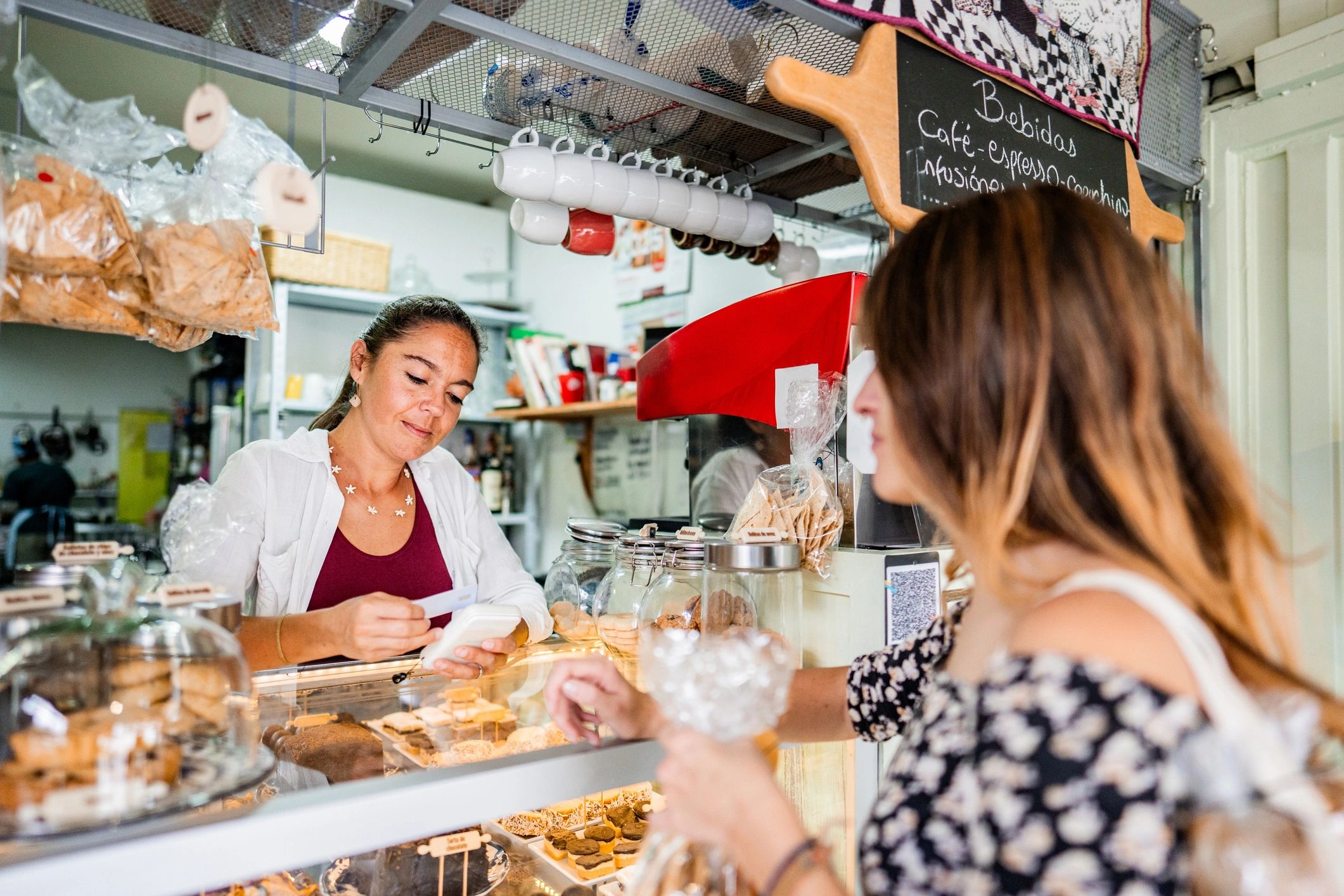 Small business vendor talking with a customer at a market booth