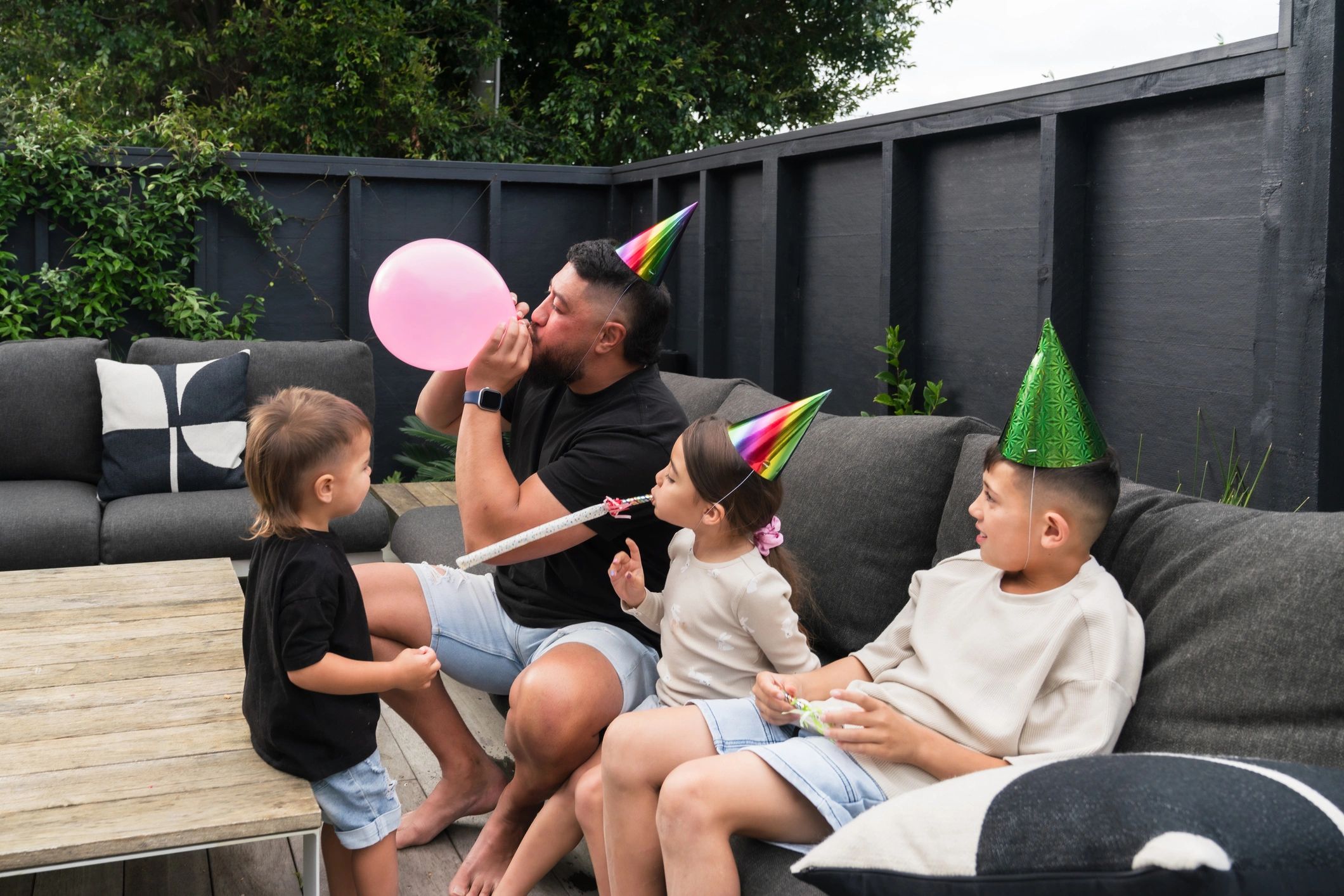 Parent and children preparing balloons for a birthday party