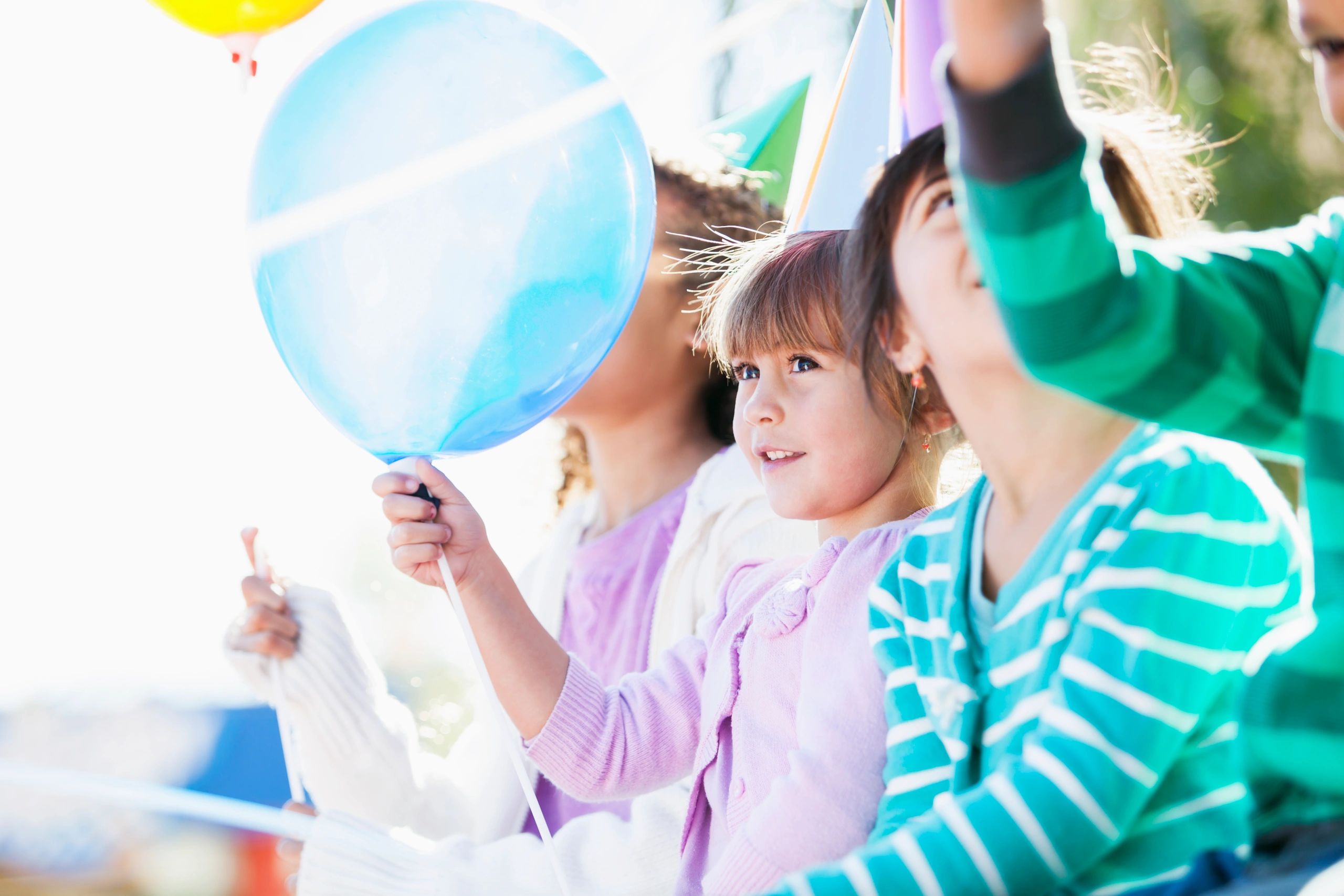 Children at a birthday party holding balloons