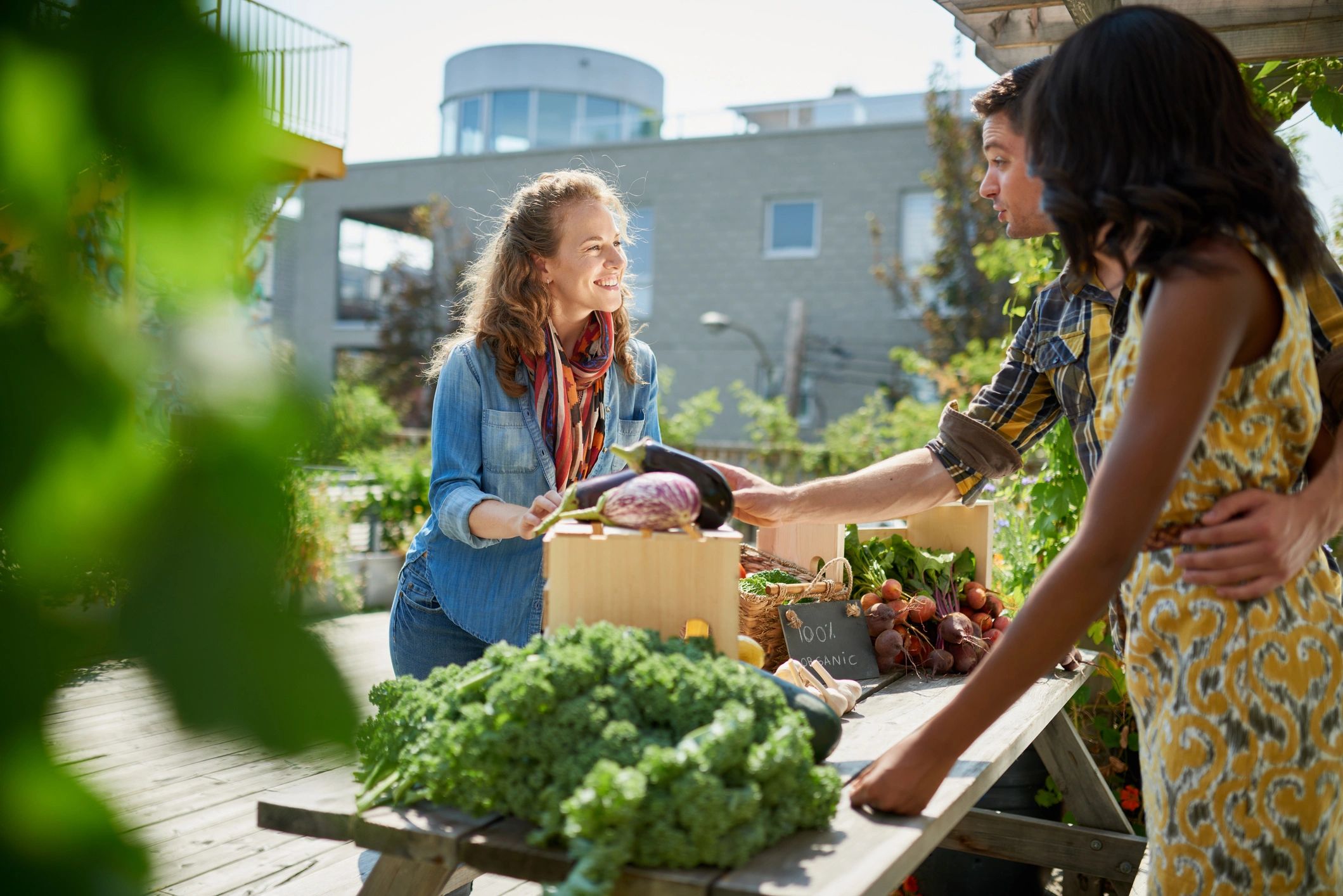 Vendor tending an organic vegetable stall at a farmers market